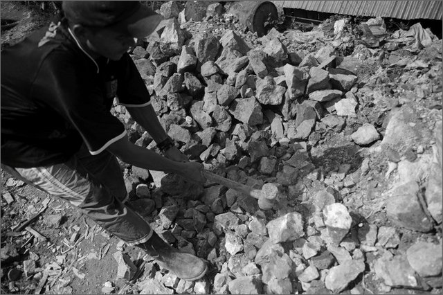 127891 - colombia - mina facil. operaio della miniera rompe i sassi con grosso martello  - giu 2012-.jpg